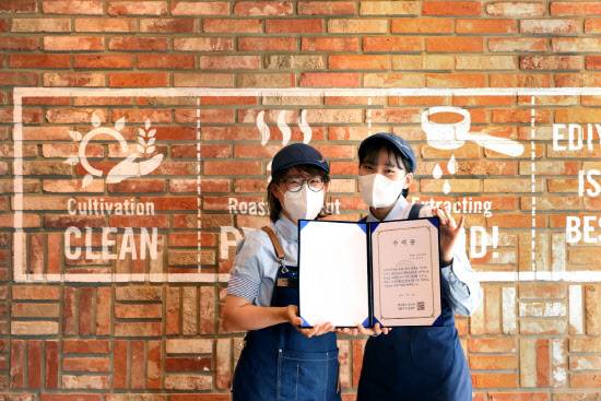 ▲2021년 하반기 ‘이디야 메이트 희망기금’에 선정된 매장 아르바이트생(이디야 메이트)들이 기념촬영을 하고 있다.(사진=이디야커피)