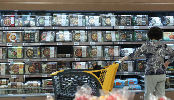 A customer shopping for packaged Chuseok foods at a major shopping mart in Seoul on Thursday. In the past, families would gather to make dishes enjoyed during the Chuseok holidays including songpyeon, or rice cakes steamed with pine leaves. More recently, these meal kits have gained popularity. According to Shinsegae's online shopping mall, such meal kit sales were up 12 percent between Aug. 31 and Sept. 13 when compared to the two weeks prior to the Chuseok holidays in 2020. [YONHAP]