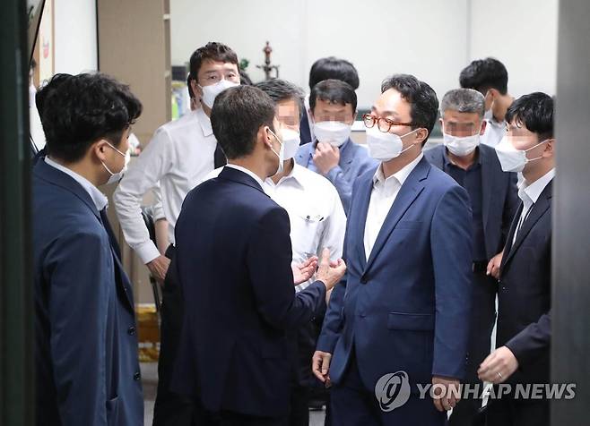 압수수색 마친 공수처 관계자 국민의힘 김웅 의원(왼쪽)이 지난 13일 국회 의원회관 내 사무실에서 압수수색을 마친 뒤 대화하는 고위공직자범죄수사처(공수처) 예상균 검사와 수사관 등을 지켜보고 있다.  [국회사진기자단]