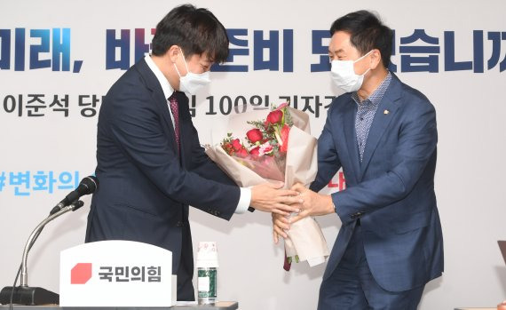 이준석 국민의힘 대표가 17일 서울 여의도 국민의힘 중앙당사에서 취임 100일 기자간담회에서 김기현 원내대표로부터 축하 꽃다발을 받고 있다. .2021.9.17/뉴스1 © News1 오대일 기자 /사진=뉴스1