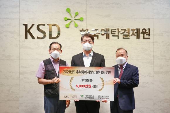 정찬용 부산남구장애인협회장(왼쪽부터)과 이명호 한국예탁결제원 KSD나눔재단 이사장, 김복명 부산시각장애인복지연합회장이 지난 16일 열린 한국예탁결제원 KSD나눔재단의 '사랑의 쌀 나눔 행사'에서 후원물품 전달식을 진행하고 기념촬영하고 있다. [사진=한국예탁결제원]