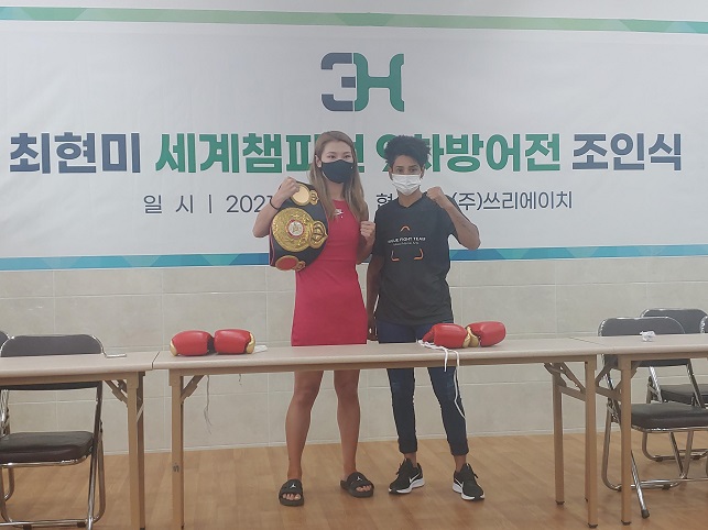 최현미(왼쪽)가 17일 서울 제기동 3H 강당에서 열린 WBA 슈퍼페더급 챔피언 타이틀 9차 방어전 계체에서 도전자인 시모네 다 실바와 기념촬영을 하고 있다.