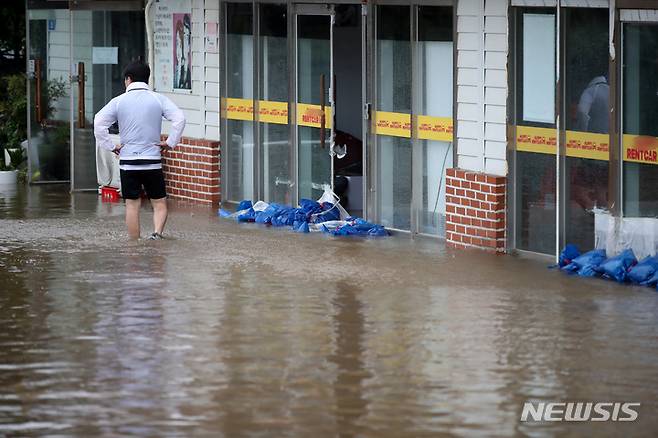 [제주=뉴시스] 우장호 기자 = 제14호 태풍 '찬투(CHANTHU)'가 제주를 통과한 17일 오전 제주시 용담2동에 위치한 상가 건물과 부지가 불어난 빗물에 침수돼 배수작업이 이뤄지고 있다. 2021.09.17. woo1223@newsis.com