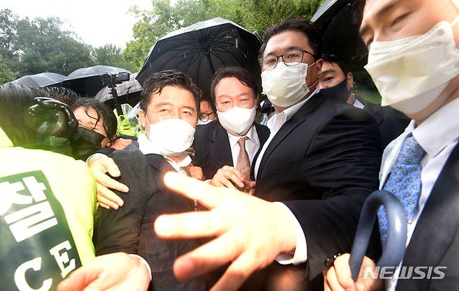 [구미=뉴시스] 이무열 기자 = 윤석열 국민의힘 대선 경선 후보가 17일 오전 경북 구미시 상모동 박정희 전 대통령 생가를 찾아 분향을 마친 뒤 박근혜 전 대통령 구속에 항의하는 보수단체 회원들이 대거 몰리자, 경찰의 호위를 받으며 생가를 나오고 있다. 2021.09.17. lmy@newsis.com