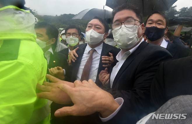 [구미=뉴시스] 이무열 기자 = 윤석열 국민의힘 대선 경선 후보가 17일 오전 경북 구미시 상모동 박정희 전 대통령 생가를 찾아 분향을 마친 뒤 박근혜 전 대통령 구속에 항의하는 보수단체 회원들이 대거 몰리자, 경찰의 호위를 받으며 생가를 나오고 있다. 2021.09.17. lmy@newsis.com