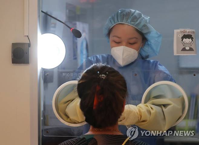 추석 연휴 반납한 의료진 (서울=연합뉴스) 한종찬 기자 = 18일 서울 중구보건소 선별진료소에서 의료진이 코로나19 검체 검사를 하고 있다. 2021.9.18 saba@yna.co.kr