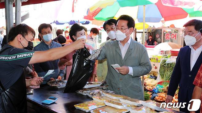 김영록 전라남도지사가 추석 명절을 맞아 19일 오전 순천 덕암동 순천역전시장을 방문, 순천사랑 상품권으로 주요 성수품을 구매하며 코로나로 어려움을 겪고 있는 상인들을 격려하고 있다.(전남도 제공) 2021.9.19/뉴스1 © News1
