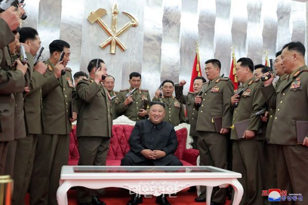 김정은 북한 국무위원장이 지난해 7월 권총을 치켜든 군 지휘관들과 함께 기념촬영을 하고 있다. ⓒ조선중앙통신