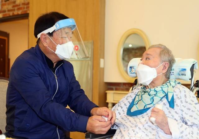 지난 17일 경기 광주시 선한빛요양병원에서 2개월만에 만난 입소 환자 박정이 씨와 남편 최병록 씨가 대면 면회를 하고 있다. 보건복지부 제공