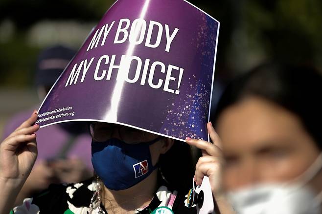 한 여성이 지난 15일(현지시간) 미국 워싱턴 D.C.에 위치한 연방 대법원 앞에서 텍사스주 낙태 금지법에 반발하는 피켓을 들고 있다. [로이터]