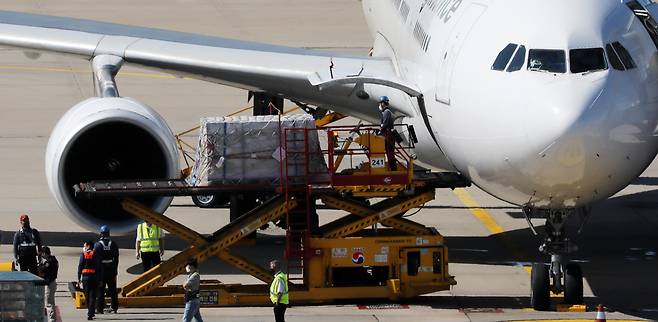 지난 8일 오후 인천국제공항 화물터미널에서 관계자들이 코로나19 백신을 옮기고 있다. [연합]