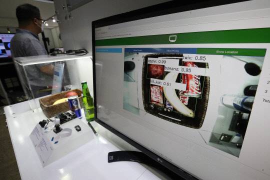 지난 8일 서울 강남구 코엑스에서 열린 '스마트공장ㆍ 자동화산업전 2021'에서 로봇이 상자 속 제품을 인지해 모니터에 띄어 보이고 있다. 연합뉴스