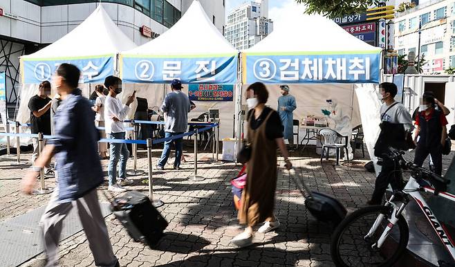 추석 연휴 마지막 날인 22일 오전 서울 광진구 동서울터미널에 설치된 코로나19 임시 선별검사소 앞을 귀경객들이 분주하게 이동하고 있다. 이 임시 선별 검사소는 추석 연휴 기간 터미널을 이용할 이용객들을 위해 운영되고 있다. 연합뉴스