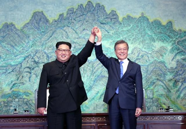 - 문재인 대통령과 김정은 국무위원장이 2018년 4월 27일 오후 판문점에서 ‘판문점 선언문’에 서명한 뒤 맞잡은 손을 들어올리고 있다. 판문점=연합뉴스