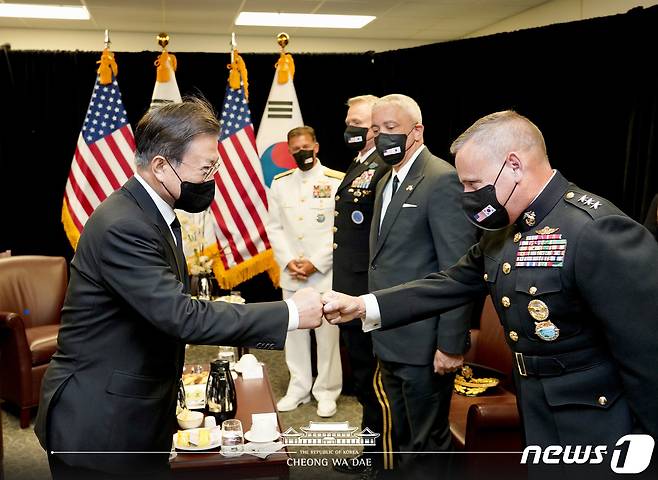 문재인 대통령이 22일(현지시간) 하와이 호놀룰루 히캄 공군기지 격납고 회의실에서 기지 관계자들과 인사나누고 있다.(청와대 페이스북)2021.9.23/뉴스1