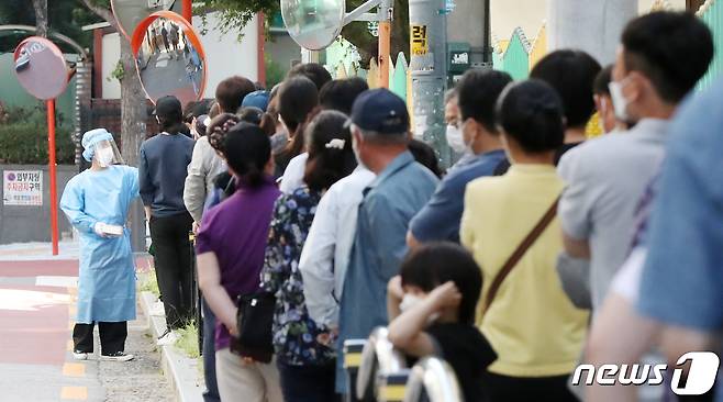 23일 오전 서울 구로구 보건소에 마련된 신종 코로나바이러스 감염증(코로나19) 선별진료소에서 시민들을 비롯한 국내 거주 외국인 노동자들이 코로나19 진단 검사를 받기 위해 길게 줄을 서 있다. 2021.9.23/뉴스1 © News1 민경석 기자