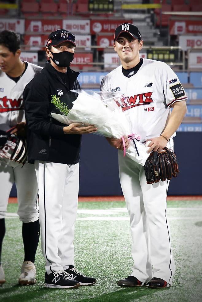KT 이강철 감독이 통산 100세이브를 달성한 마무리 김재윤에게 축하의 꽃다발을 전하고 있다. 사진제공=KT 위즈