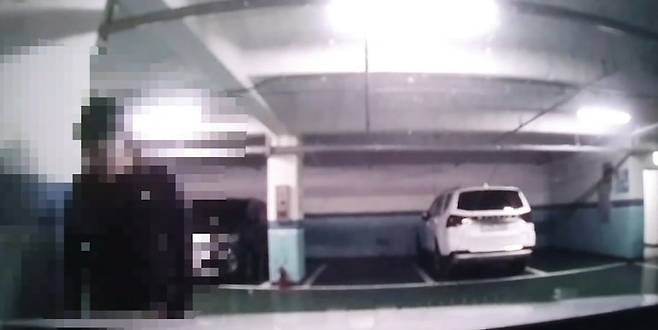 23일 한 온라인 커뮤니티에 올라온 영상 중 한 장면. 한 남성(B씨)이 한 여성(A씨)의 차량으로 다가가 전화번호를 확인하는 모습으로 보인다. 영상은 A씨의 차량 블랙박스 영상 중 일부만 올라왔다. /온라인커뮤니티