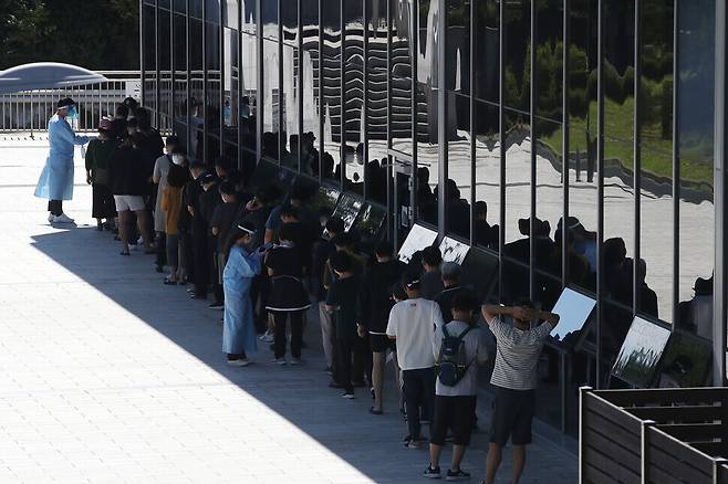 People returning to Seoul after the holiday wait to be tested for COVID-19 outside a temporary screening station at Suseo Station in Seoul’s Gangnam District on Wednesday. (Yonhap News)
