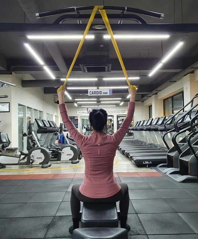 밴드를 높은 곳에 걸고, 밴드 양 끝을 손으로 단단히 잡는다. 피트니스위 제공