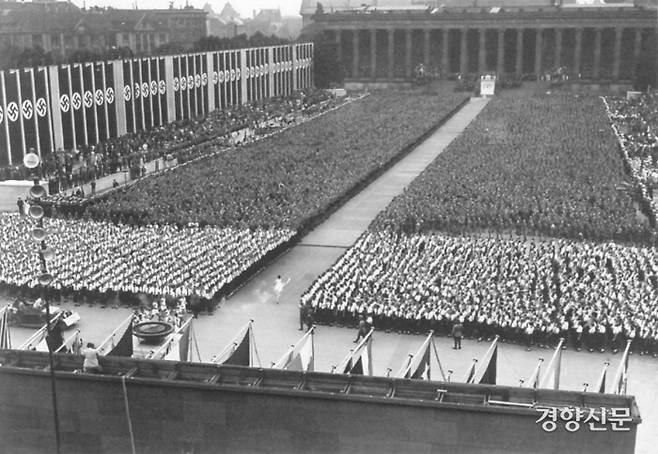 베를린 올림픽 성화를 든 단독 주자가 완벽하게 통제된 대규모 군중 사이로 올림픽 주경기장 제단을 향해 달려가고 있다. 올림픽 성화는 10만 명 정도의 관중 앞에서 점화됐다. 페이퍼로드 제공