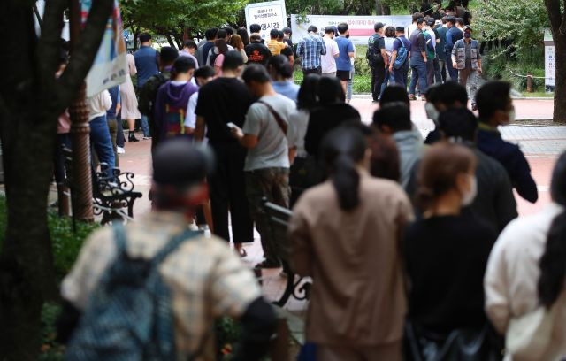 24일 오후 대구 중구 국채보상공원에 마련된 임시선별검사소에서 시민들이 검사를 받기 위해 길게 줄지어 기다리고 있다. 연합뉴스