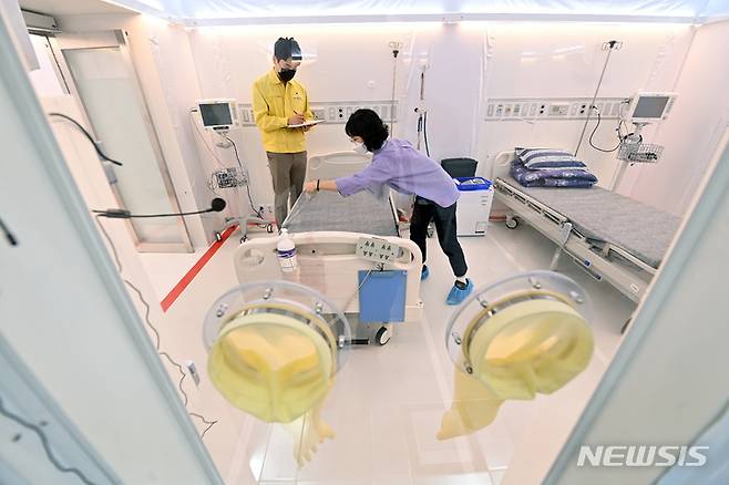[수원=뉴시스] 경기사진공동취재단 = 8일 오후 경기도 수원시 경기도인재개발원 실내체육관에 마련된 경기도 제2호 특별생활치료센터에서 관계자들이 이동형 음압병동 시설을 점검하고 있다. 28병상 규모로 설치된 이동형 음압병동은 대면 치료가 가능한 의료인력 및 엑스레이실, 처치실을 갖추고 있어 기존 생활치료센터의 취약점을 보완했다. 2021.09.08.photo@newsis.com