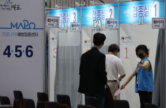 24일 서울 마포구민체육센터에 마련된 코로나19 예방접종센터에서 시민들이 백신을 접종하기 주사실로 향하고 있다. <연합뉴스>