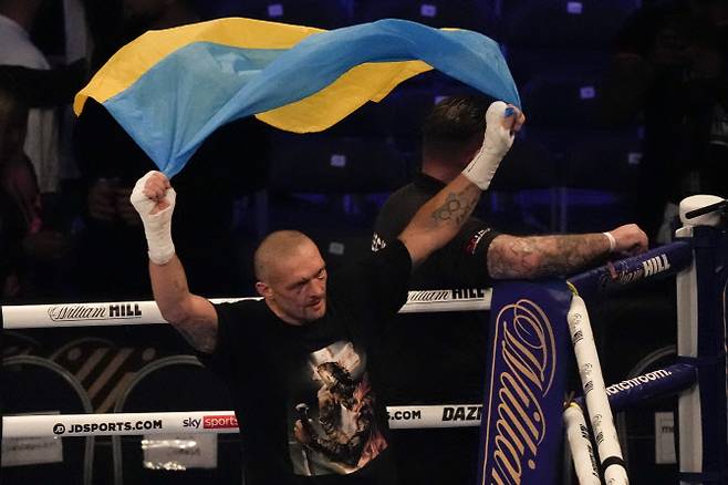 올렉산드르 유시크가 헤비급 통합챔피언에 등극한 뒤 우크라이나 국기를 들고 기뻐하고 있다. 사진=AP PHOTO