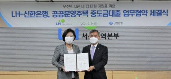 이정관 한국토지주택공사(LH) 부사장(오른쪽)과 조경선 신한은행 부행장이 지난 24일 LH서울지역본부에서 공공분양주택 수분양자의 자금부담 완화를 위한 '중도금 대출 업무 협약'을 체결한 후 기념촬영을 하고 있다.