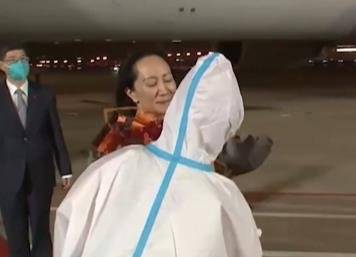 멍 부회장에 방호복으로 무장한 직원이 꽃다발을 건넸다. 멍 부회장은 마스크를 착용하지 않았다. [하오칸스핀 캡쳐]