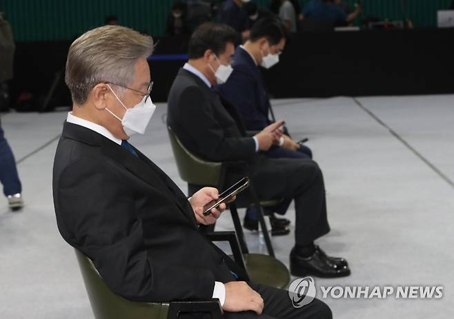 경선 결과 확인하는 민주당 경선 주자들 (완주=연합뉴스) 최영수 기자 = 26일 전북 완주군 우석대학교 체육관에서 열린 더불어민주당 대선 후보 선출을 위한  전북 합동연설회 후 후보들이 경설결과를 휴대전화로 확인하고 있다. 왼쪽부터 이재명, 이낙연, 박용진 후보
.      2021.9.26 kan@yna.co.kr