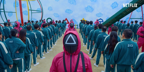 A scene from “Squid Game” shows the survival game players in green track suits. [NETFLIX]