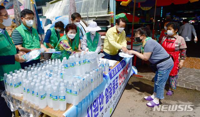 [광주=뉴시스] 류형근 기자 =  동구청 직원들이 시장 상인과 이용객들에게 얼음 생수를 나눠주고 있다. 2021.08.10. hgryu77@newsis.com