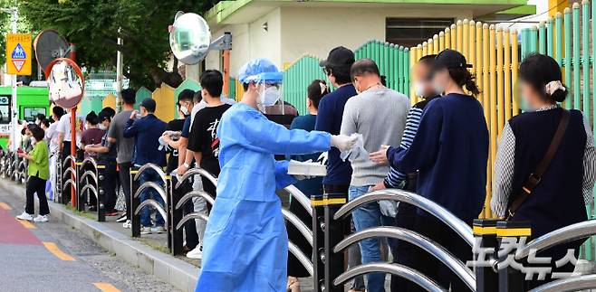코로나19 마련된 선별진료소에서 의료진이 시민들에게 비닐장갑을 나눠주고 있다. 황진환 기자