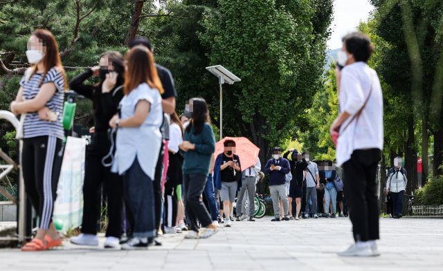 임시 선별진료소에서 시민들이 검사를 받기 위해 줄지어 서 있다./연합뉴스