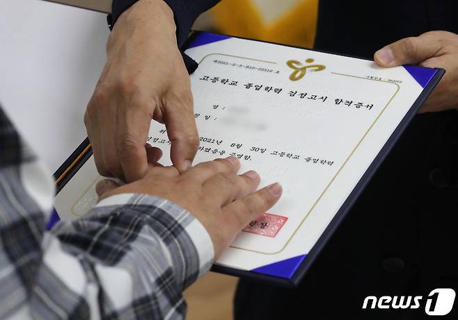 조희연 서울시교육감이 28일 서울 노원구 노원시각장애인복지관에서 열린 '2021년 제2회 찾아가는 검정고시 합격증서 수여식'에서 시각장애인 합격자에게 점자로 된 합격증을 읽어주고 있다. 2021.9.28/뉴스1 © News1 이성철 기자