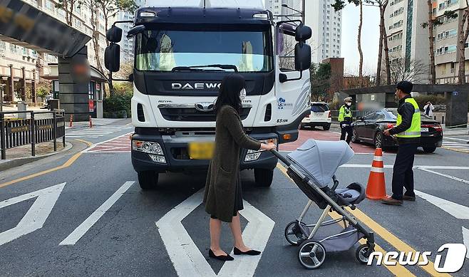 18일 오전 광주 북구 운암동 어린이보호구역 사고 현장에서 현장검증이 진행되는 가운데 피해자 대역의 한 여성이 유모차를 끌고 화물차 앞에 서있다. 재판부는 피해자가 보이지 않았다는 운전자 진술을 토대로 과실 입증을 위한 현장 검증을 실시했다. 지난해 11월 광주 스쿨존에서 발생한 사고로 4명의 일가족이 화물차에 치여 3세 여아가 숨졌다. 해당 재판의 다음 공판기일은 4월 14일로 예고됐다.(광주지법 제공)2021.3.18/뉴스1 © News1 허단비 기자