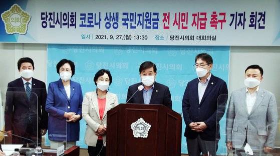 최창용 의장(왼쪽 네 번째)을 비롯한 충남 당진시의원들이 지난 27일 시의회 대회실에서 기자회견을 열고 코로나 상생 국민지원금 전 시민 지급을 당진시에 촉구하고 있다. 연합뉴스