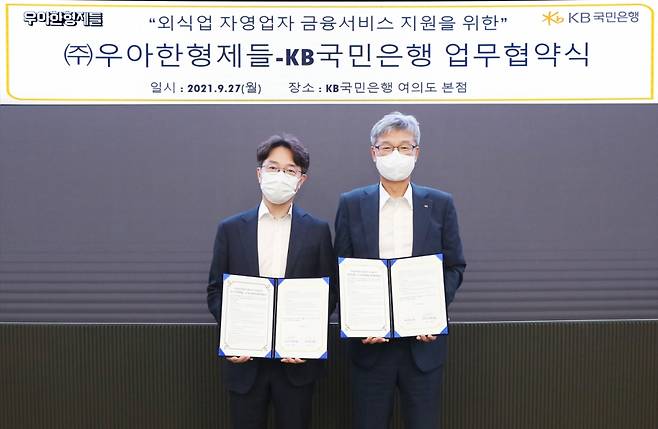 김범준 우아한형제들 김범준 대표(왼쪽)와 KB국민은행 허인 은행장이 27일 서울 영등포구 KB국민은행 여의도 본점에서 ‘외식업 자영업자 금융서비스 지원을 위한 업무협약’을 체결했다. /사진=우아한형제들