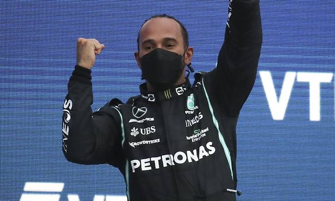 루이스 해밀턴이 27일 러시아 크라스노다르 크라이의 소치 아우토드롬에서 끝난 2021 러시아 그랑프리 결승에서 우승하며 통산 100승을 달성한 뒤 트로피를 들어올리며 기뻐하고 있다. 크라스노다르=TASS연합뉴스