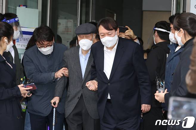 윤석열 전 검찰총장이 지난 4월2일 오전 서울 서대문구 남가좌1동주민센터에 마련된 사전투표소에서 부친 윤기중 연세대 명예교수와 함께 투표를 마친 후 투표장을 나서고 있다.  © News1 신웅수 기자