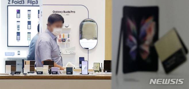 [서울=뉴시스] 홍효식 기자 = 지난달 27일 공식 출시한 갤럭시Z폴드3·플립3이 한 달이 지난 지금까지 물량 부족으로 공급 지연 현상이 빚어지고 있는 29일 오후 서울 서초구 삼성전자 서초사옥 딜라이트 샵에서 한 시민이 갤럭시Z폴드3·플립3를 살펴보고 있다. 2021.09.29. yesphoto@newsis.com