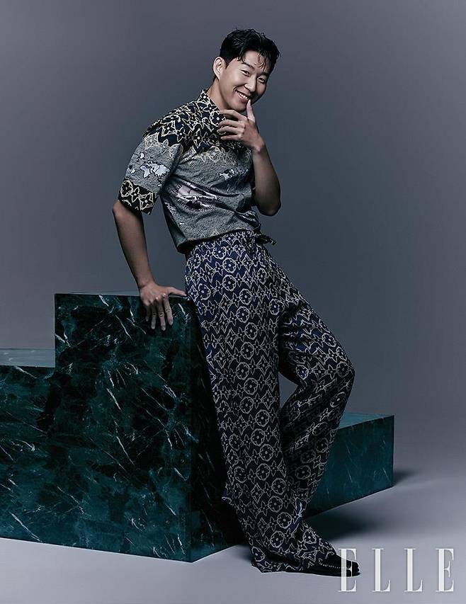 로고 패턴의 셔츠와 와이드 팬츠, 로퍼는 모두 Louis Vuitton Men’s Collection.