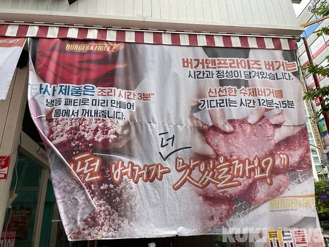해당 매장 출입문 인근에는 냉동제품보다 신선한 수제버거가 더 맛있다는 내용의 홍보물이 부착돼 있다. / 사진=신민경 기자