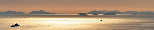 전남 진도의 조도군도가 한눈에 내려다보이는 상조도 도리산 전망대에서 내려다본 바다와 섬의 모습. 일출 무렵의 빛을 받아 금박지처럼 반짝이는 드넓은 바다 위를 배가 지나가고 있다.