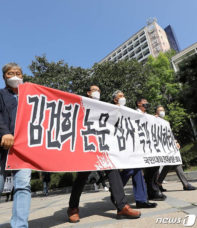 윤석열 전 검찰총장 부인 김건희씨의 박사학위 논문 '본조사 불가' 입장에 항의하는 국민대 동문들이 1일 오전 서울 성북구 국민대 본관 앞에서 졸업장을 반납하기 위해 이동하고 있다. 국민대 연구윤리위는 부정행위 의혹을 받는 김씨의 테크노디자인전문대학 박사학위 논문 '아바타를 이용한 운세 콘텐츠 개발 연구: 애니타 개발과 시장적용을 중심으로' 등 2007~2008년 작성 논문 3건에 대해 예비조사를 실시했으나 '시효만료'를 이유로 검증이 불가능하다고 결론 내렸다. 2021.10.1/뉴스1 © News1 오대일 기자