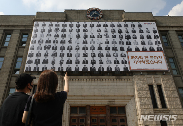 [서울=뉴시스]조수정 기자 = 제66회 현충일인 6일 서울 중구 서울도서관 외벽 꿈새김판에 국내외 6.25 참전용사 131명의 사진(사진작가 라미현의 '프로젝트 솔저' 시리즈) 전시와 함께 '마지막 한 분까지 기억하겠습니다' 라고 적혀 있다. 2021.06.06. chocrystal@newsis.com