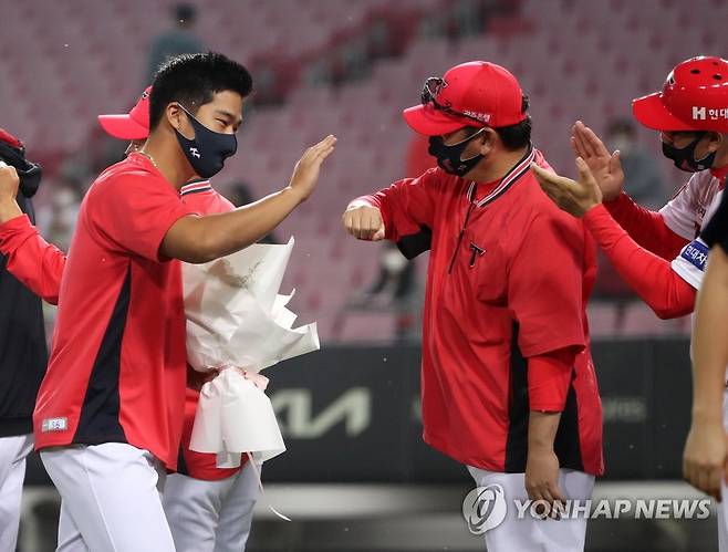 다카하시 'KBO 첫 승 신고했어요' (광주=연합뉴스) 조남수 기자 = 1일 광주-기아챔피언스필드에서 열린 2021 프로야구 키움 히어로즈와 KIA 타이거즈의 경기에서 6이닝 무실점 투구로 6-0 완승을 이끈 KIA 다카하시가 코치진으로부터 축하를 받고 있다. 2021.10.1 iso64@yna.co.kr