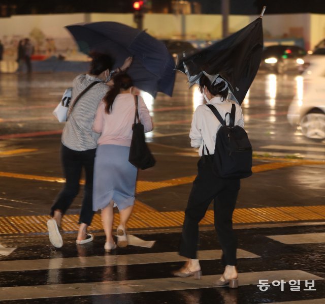 강풍을 동반한 비가 몰아친 1일 밤 서울 세종로 광화문 인근을 지나는 시민들이 우산을 부여잡고 걸음을 재촉하고 있다. 사진 신원건 기자 laputa@donga.com
